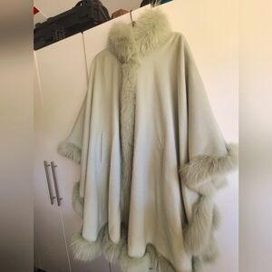 A light mint green poncho jacket with fur trim